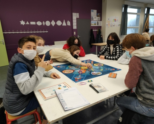 Partie de M'harcèle et moi : élèves autour du plateau de jeu géant